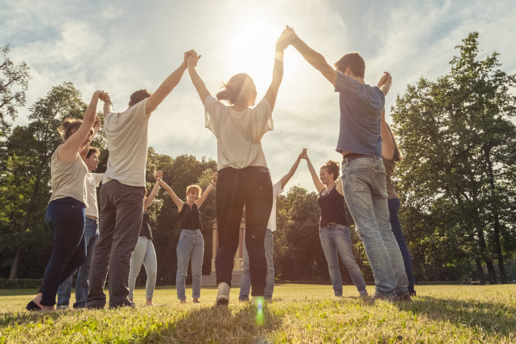 church youth members raising their hands while holding each other's hand